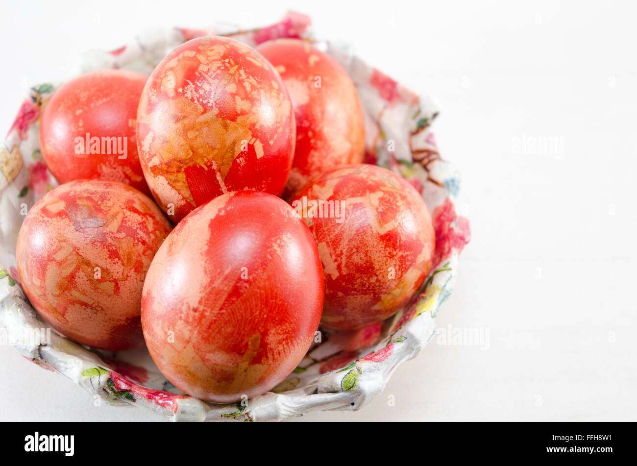 Découpage des œufs de Pâques peints à la main dans un bol décoré Banque D'Images