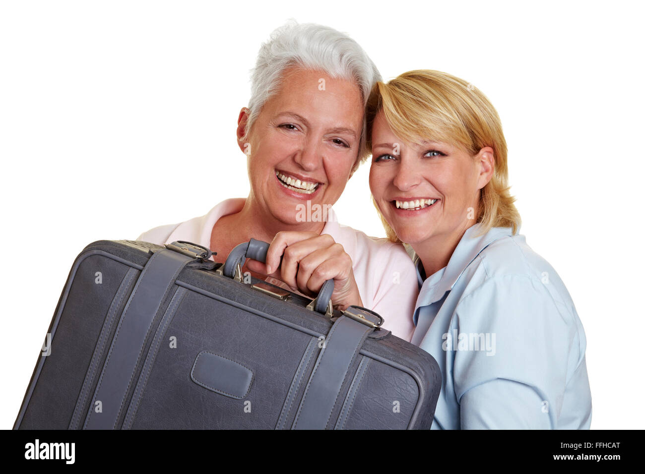 Deux happy senior Femmes portant une valise gris Banque D'Images