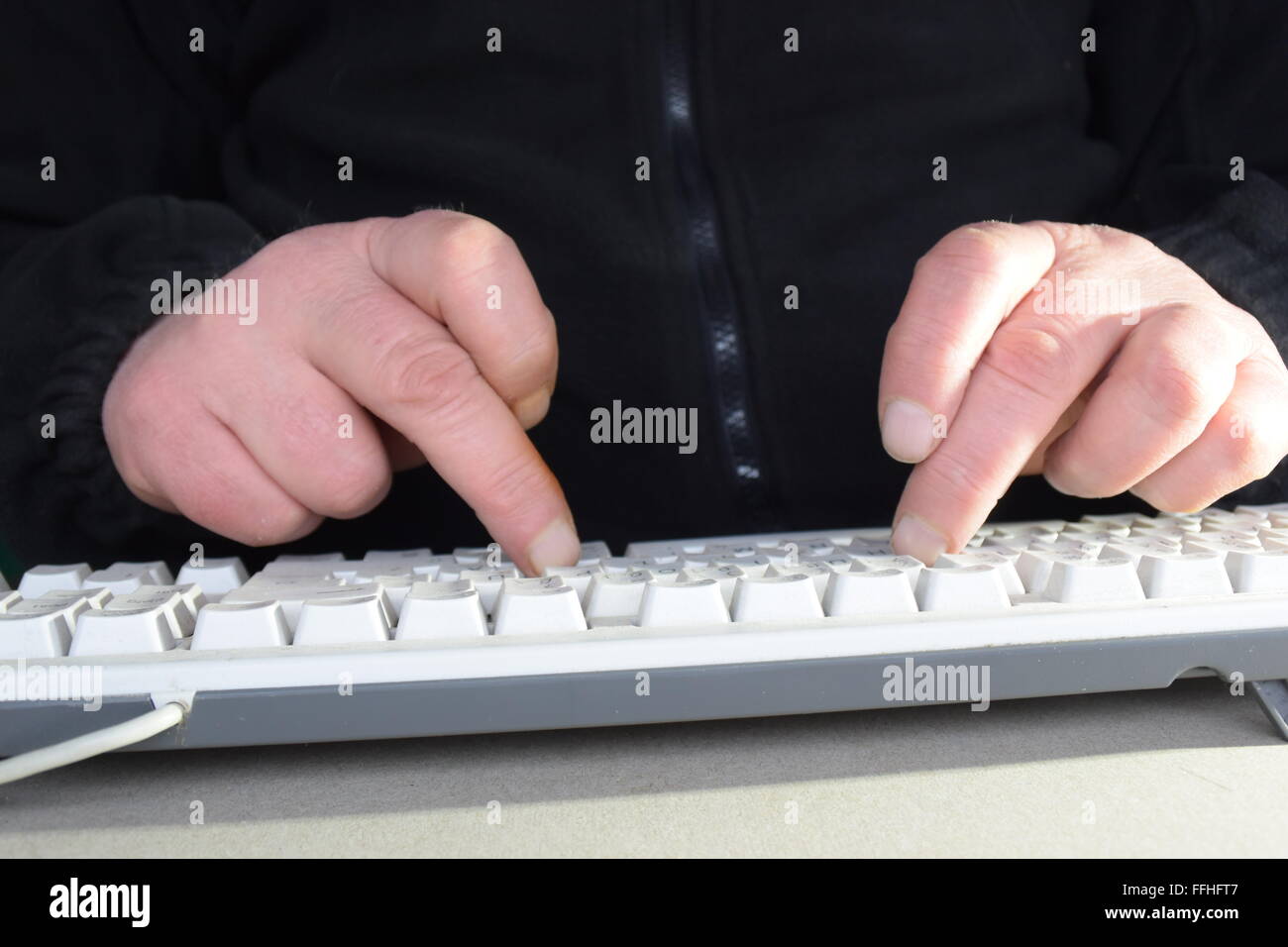 L'homme écrit sur le clavier de son ordinateur Banque D'Images