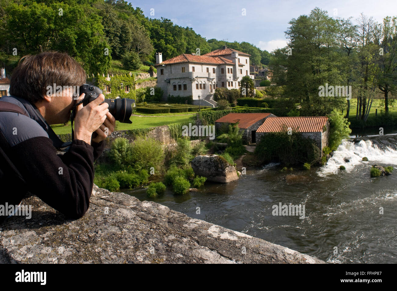 Chemin de Saint-Jacques de Compostelle, route jacquaire. Un touriste prend des photos du Ponte Maceira vers la rivière Tambre. Au chemin, St. Banque D'Images