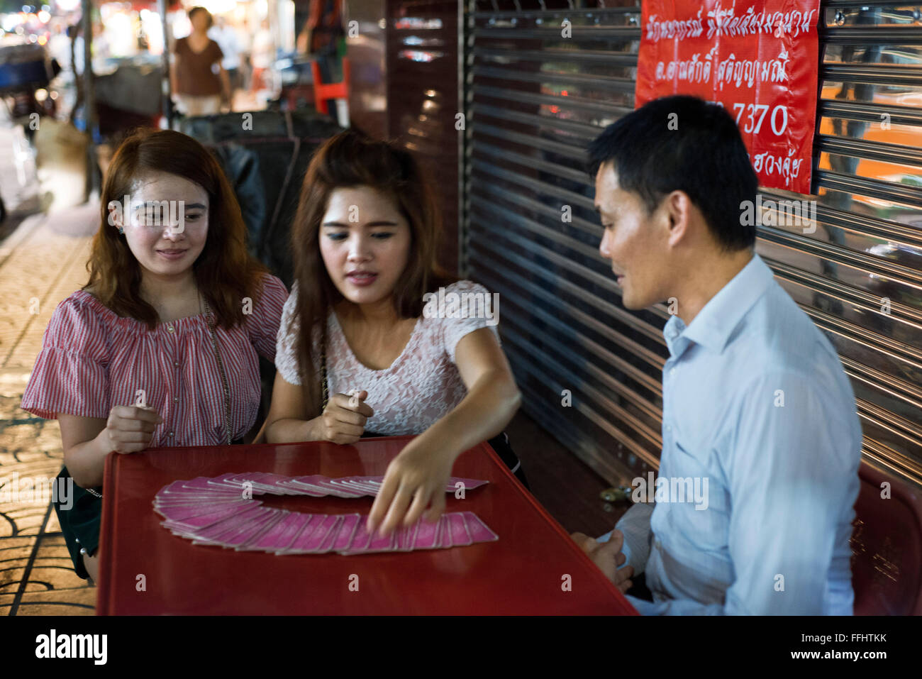 Tarot reader. Fortune Teller à Bangkok Thaïlande donnant une lecture à Yaowarat Road dans la nuit dans le centre de Chinatown district de Ban Banque D'Images