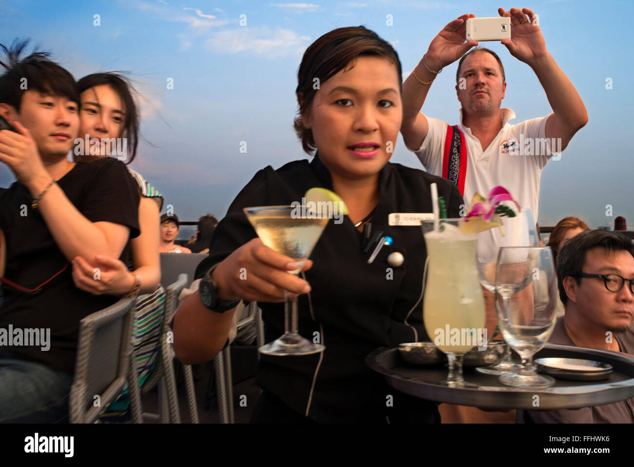 Serveuse avec un cocktail à la main. Sur le toit du Banyan Tree Vertigo & Moon Bar, Restaurant, , Bangkok , Thaïlande. Vue sur la ville, Banque D'Images