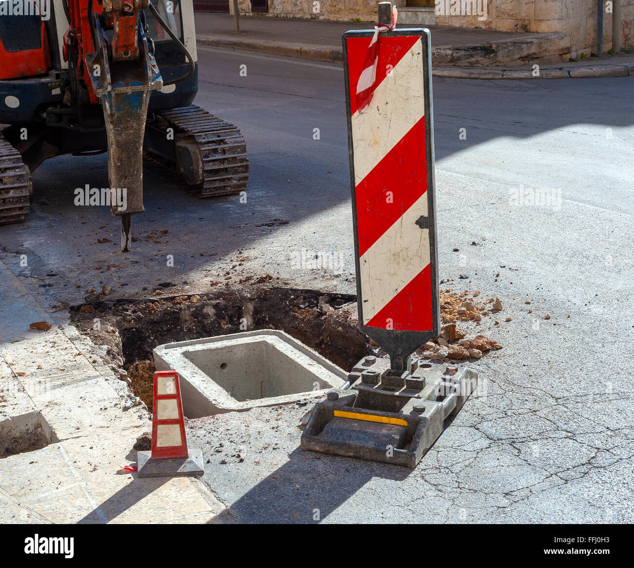 Avec excavatrice marteau hydraulique utilisé pour la réalisation d'un cockpit en ciment avec trou de fonte Banque D'Images