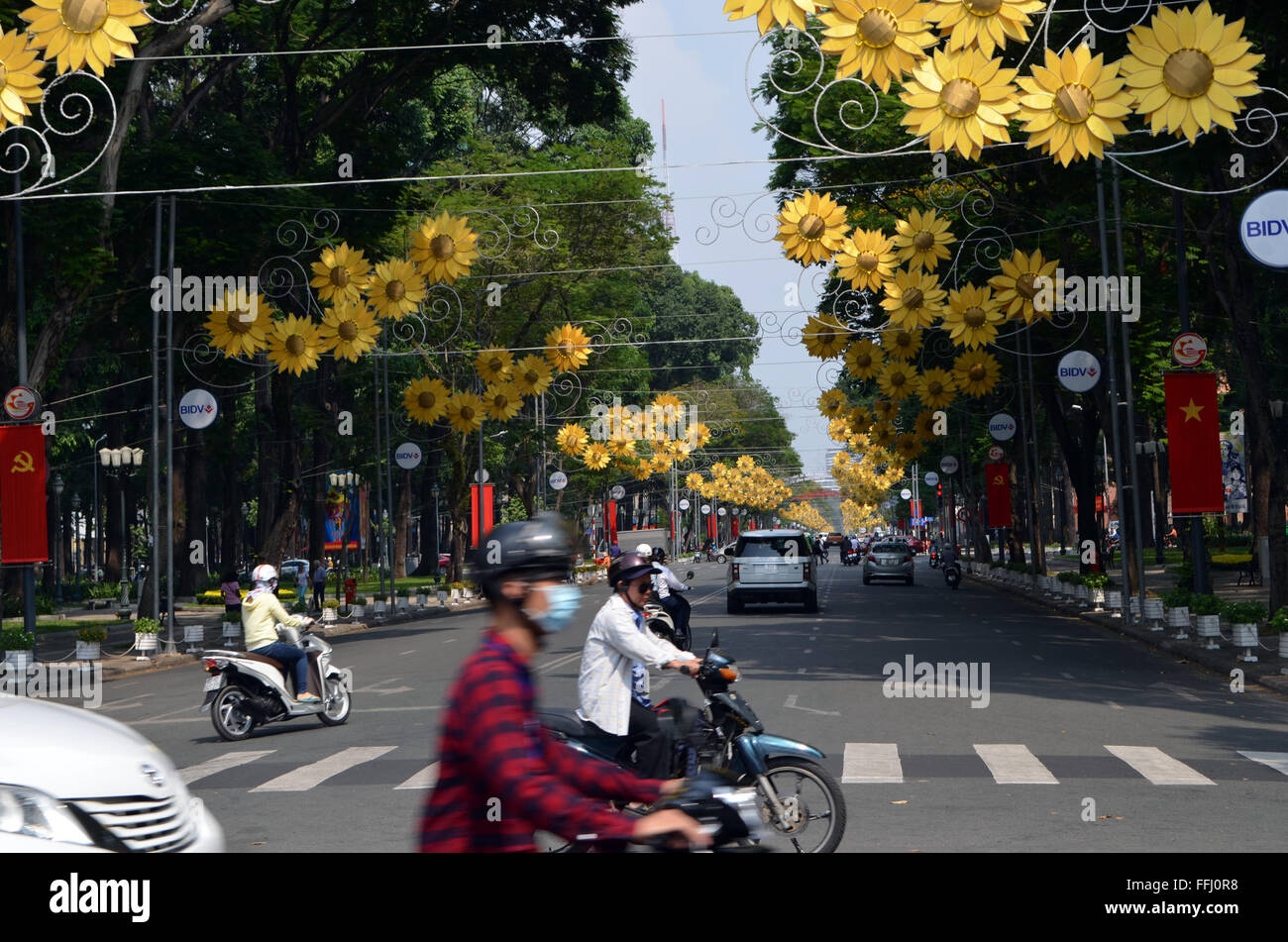 Saigon, VietNam.Les rues gaiement couvertes de bunting, drapeaux, et ces fleurs comme les gens se déplacer dans onmotor smallcars et vélos Banque D'Images