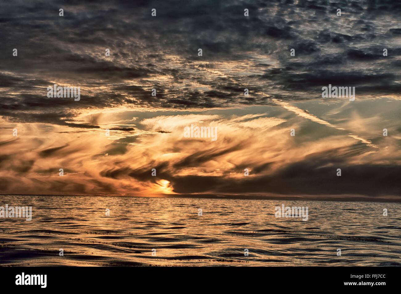 Un coucher de soleil spectaculaire sur l'océan en Californie montre la complexité des nuages couvrant le soleil couchant. Banque D'Images