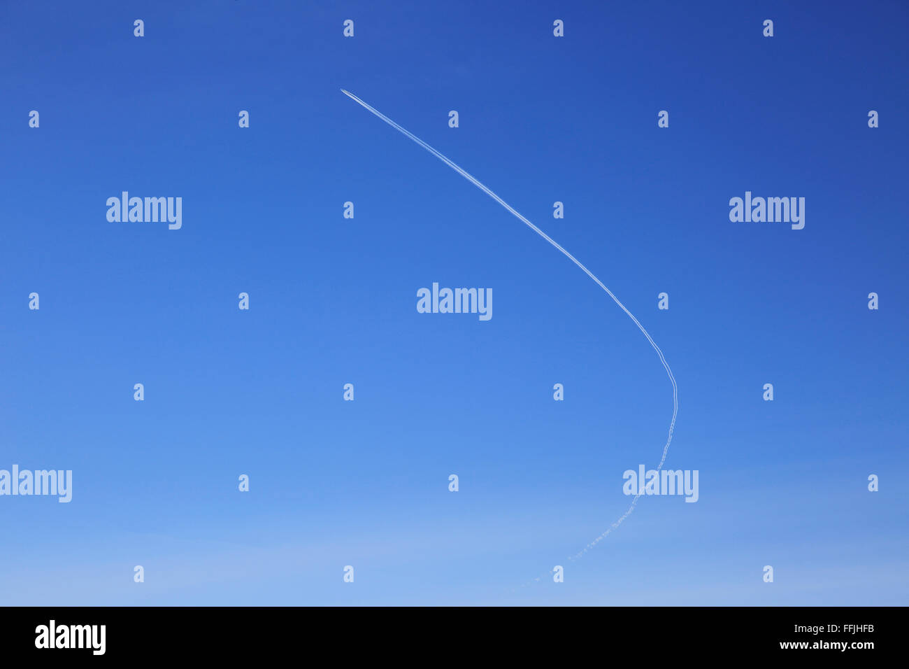 Traînée de l'avion décrit dans ciel bleu clair sur le Suffolk, Angleterre, RU Banque D'Images