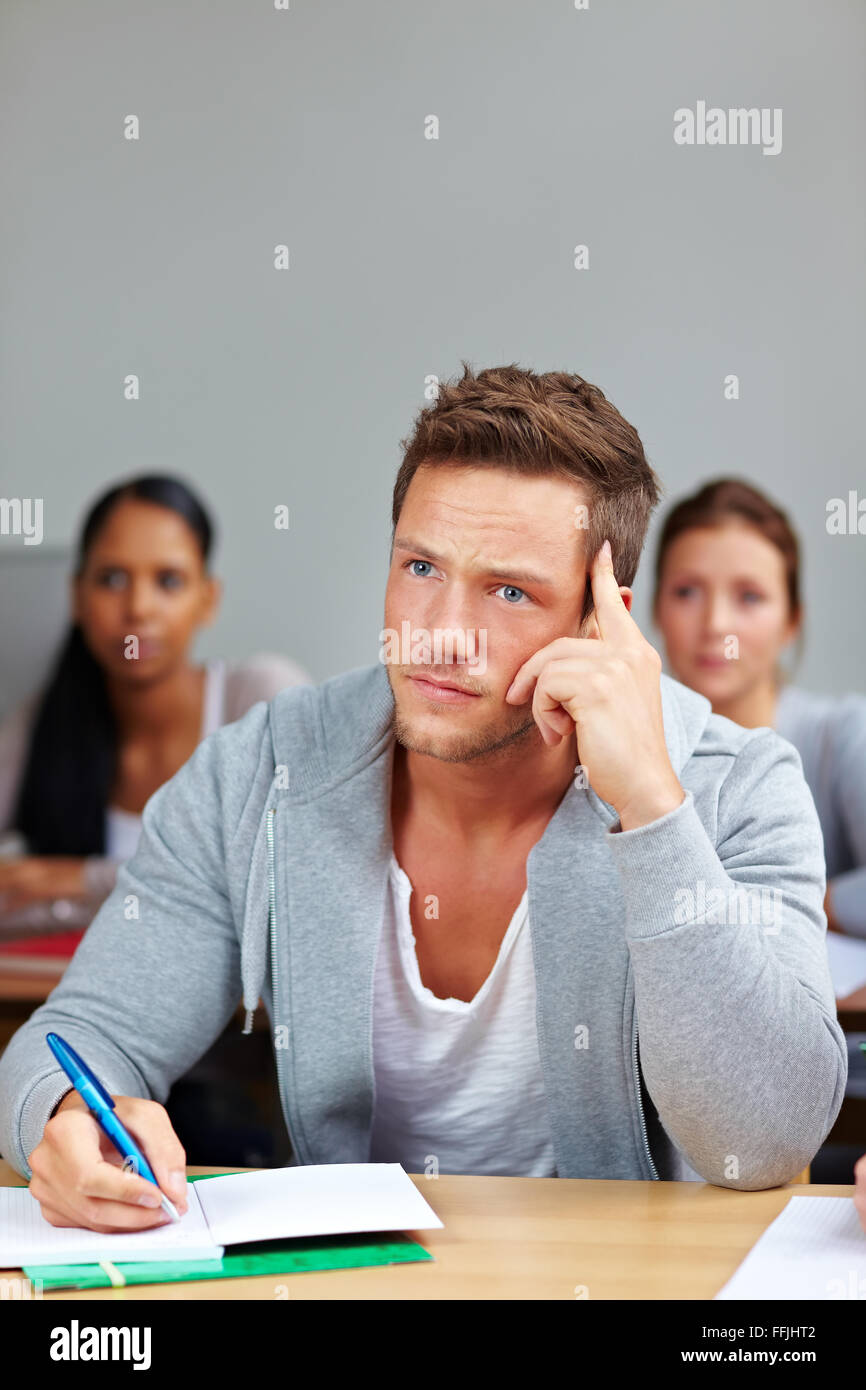 La pensée et l'étudiant pensif la prise de notes en classe universitaire Banque D'Images