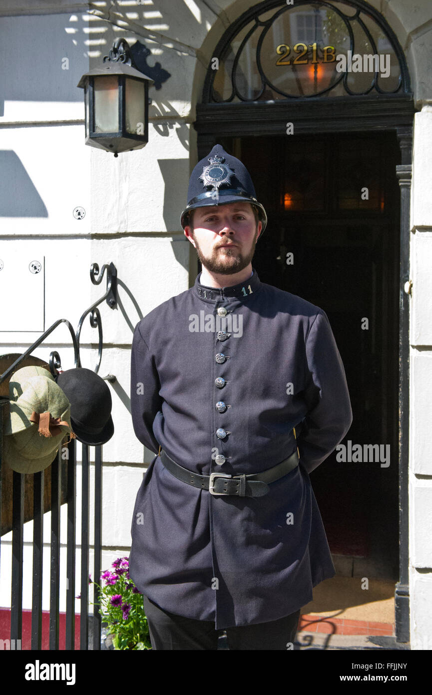 Un homme en costume (ancien uniforme de la police) à l'extérieur de la célèbre Musée Sherlock Holmes à Baker Street, London, United Kingdom. Banque D'Images