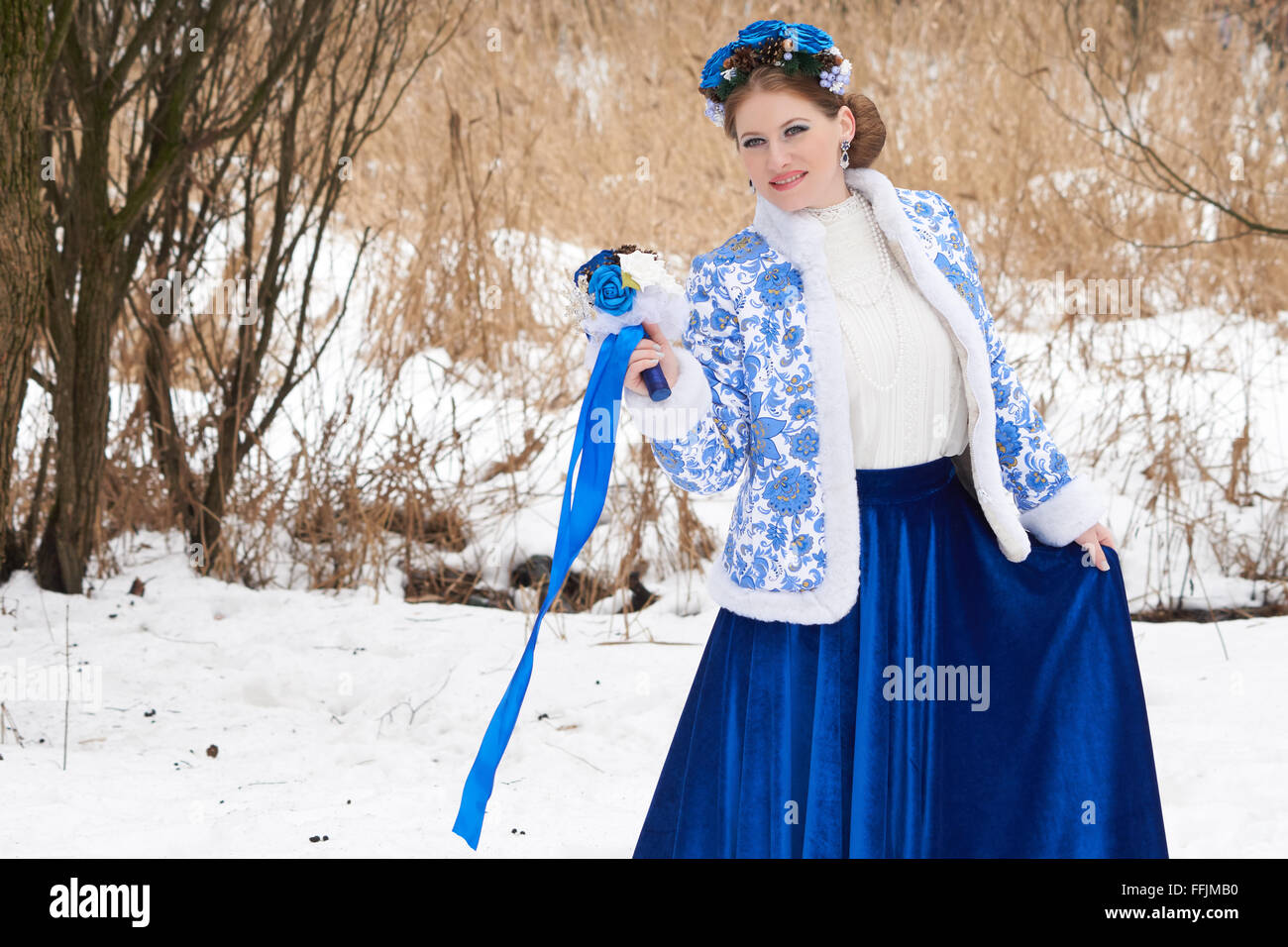 Jeune femme russe dans des vêtements d'hiver bleu avec décor sur la tête. Banque D'Images