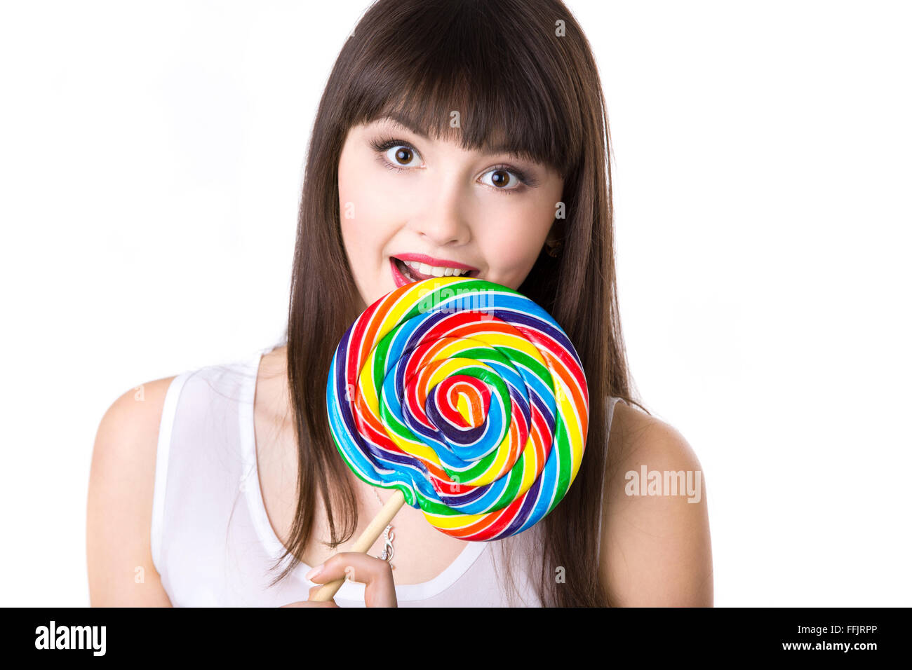 Portrait Portrait of young woman holding immense de forme ronde de couleur sucette, dupant autour, essayant de mordre candy Banque D'Images