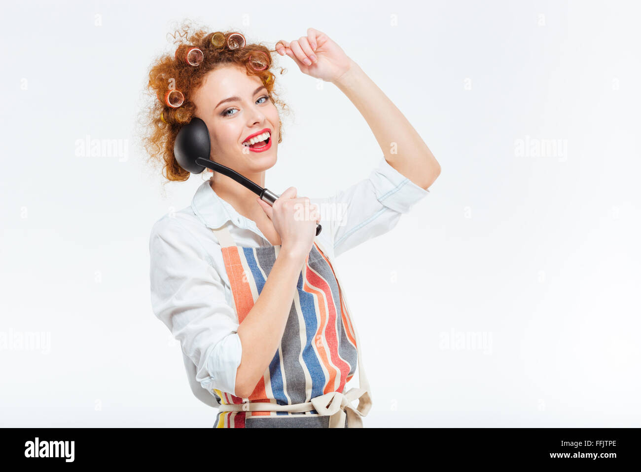 Happy housewife rousse avec les cheveux bouclés apron posant avec une louche  isolé sur fond blanc Photo Stock - Alamy