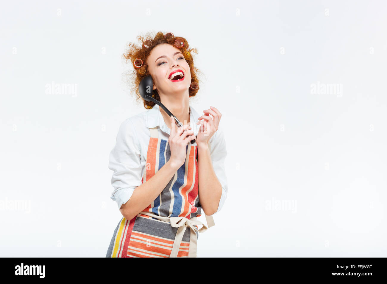 Rousse riant avec les cheveux bouclés apron posant avec une louche isolé  sur fond blanc Photo Stock - Alamy