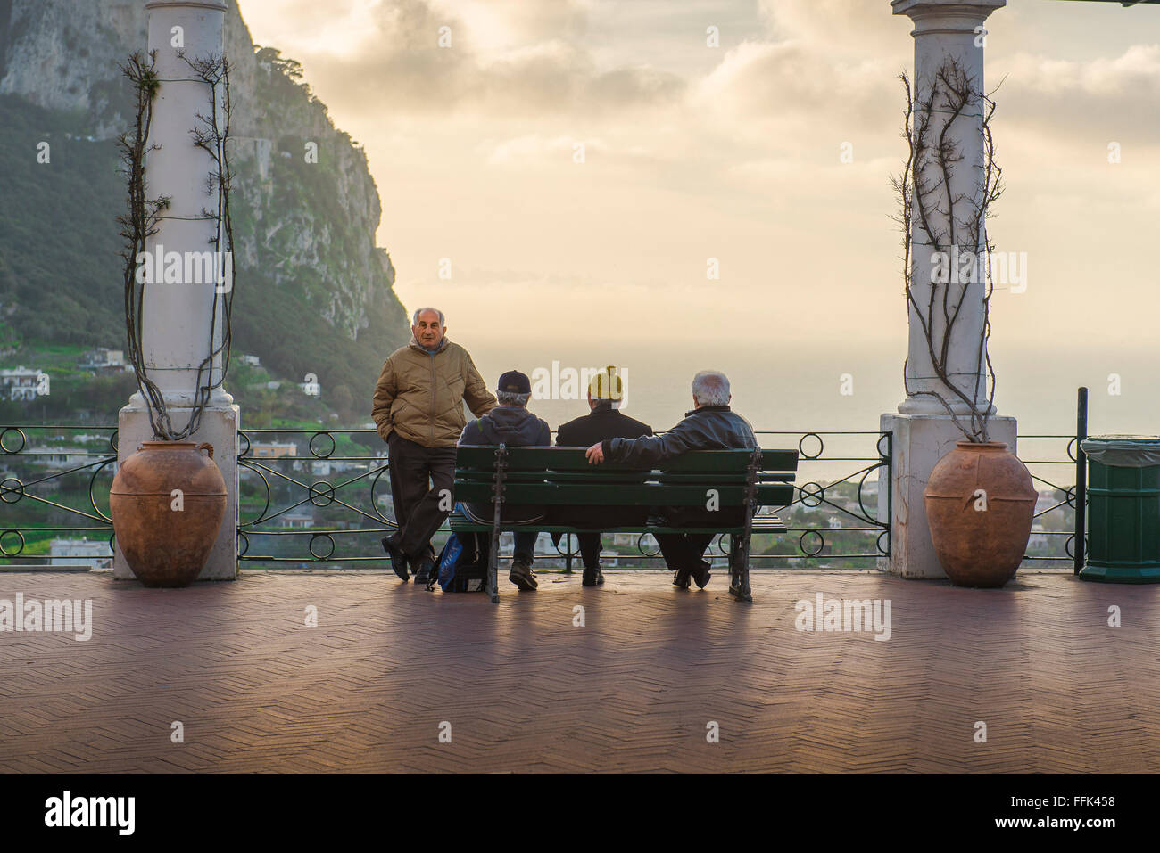 Des hommes âgés qui parlent, voient dans une soirée de printemps un groupe d'hommes locaux qui se socialisent sur la terrasse Piazzetta au centre de la ville de Capri, en Italie. Banque D'Images