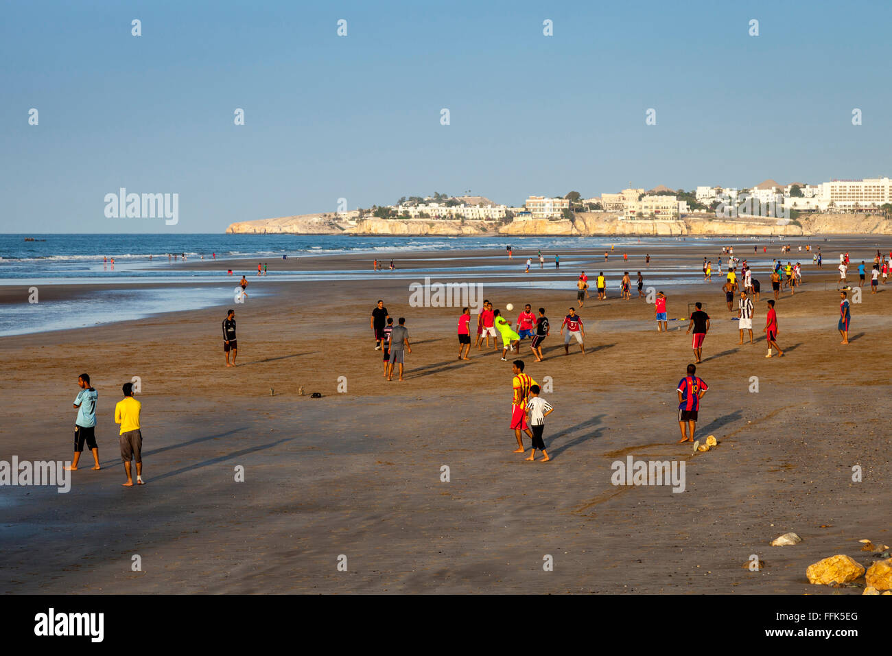 Les jeunes hommes omanais jouent au football sur la plage de Mascate, Sultanat d'Oman Banque D'Images