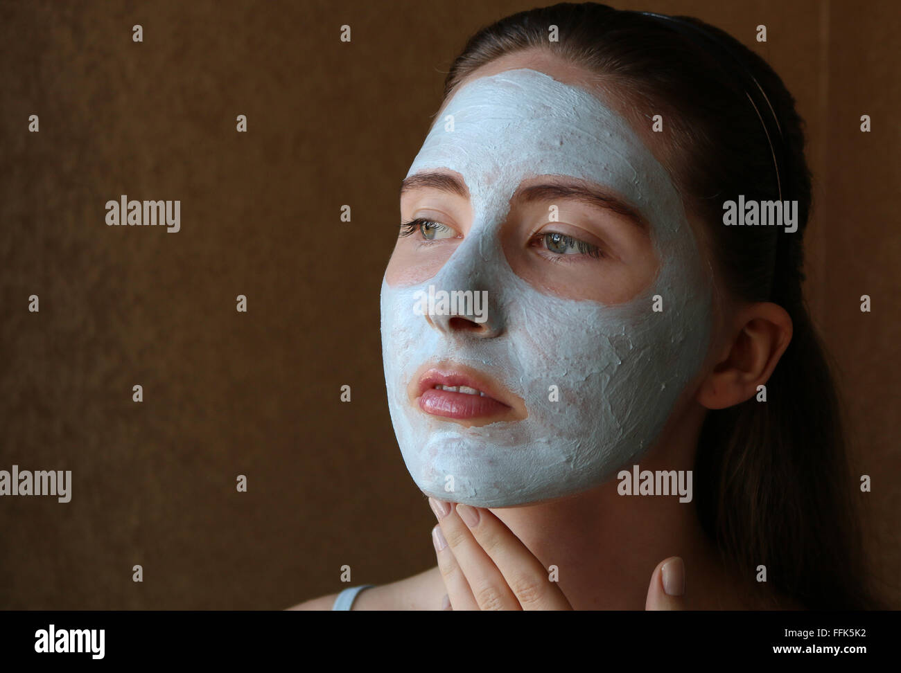 Girl doing masque cosmétique sur son visage Banque D'Images