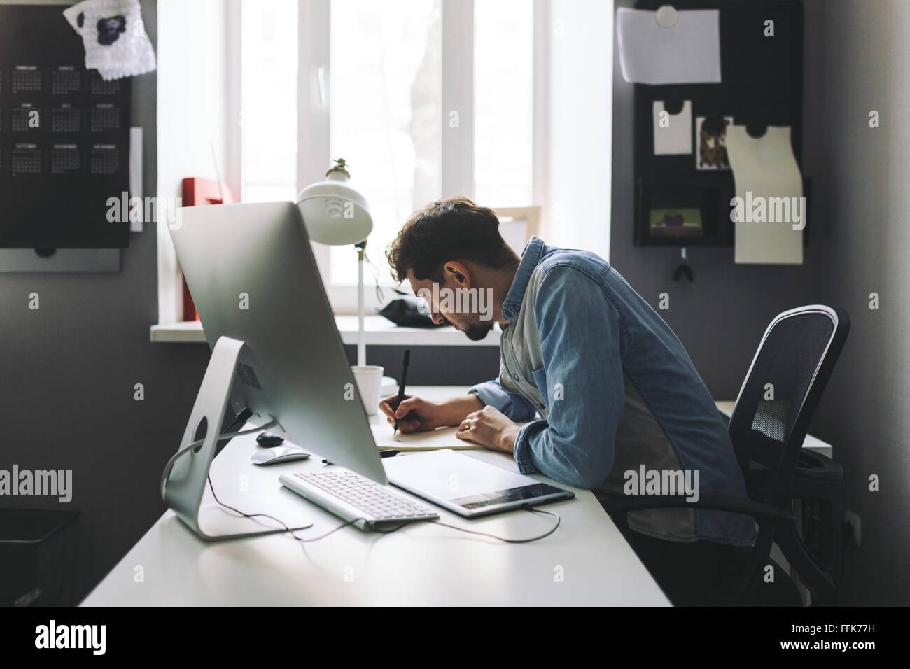 Jeune graphic designer working in office Banque D'Images