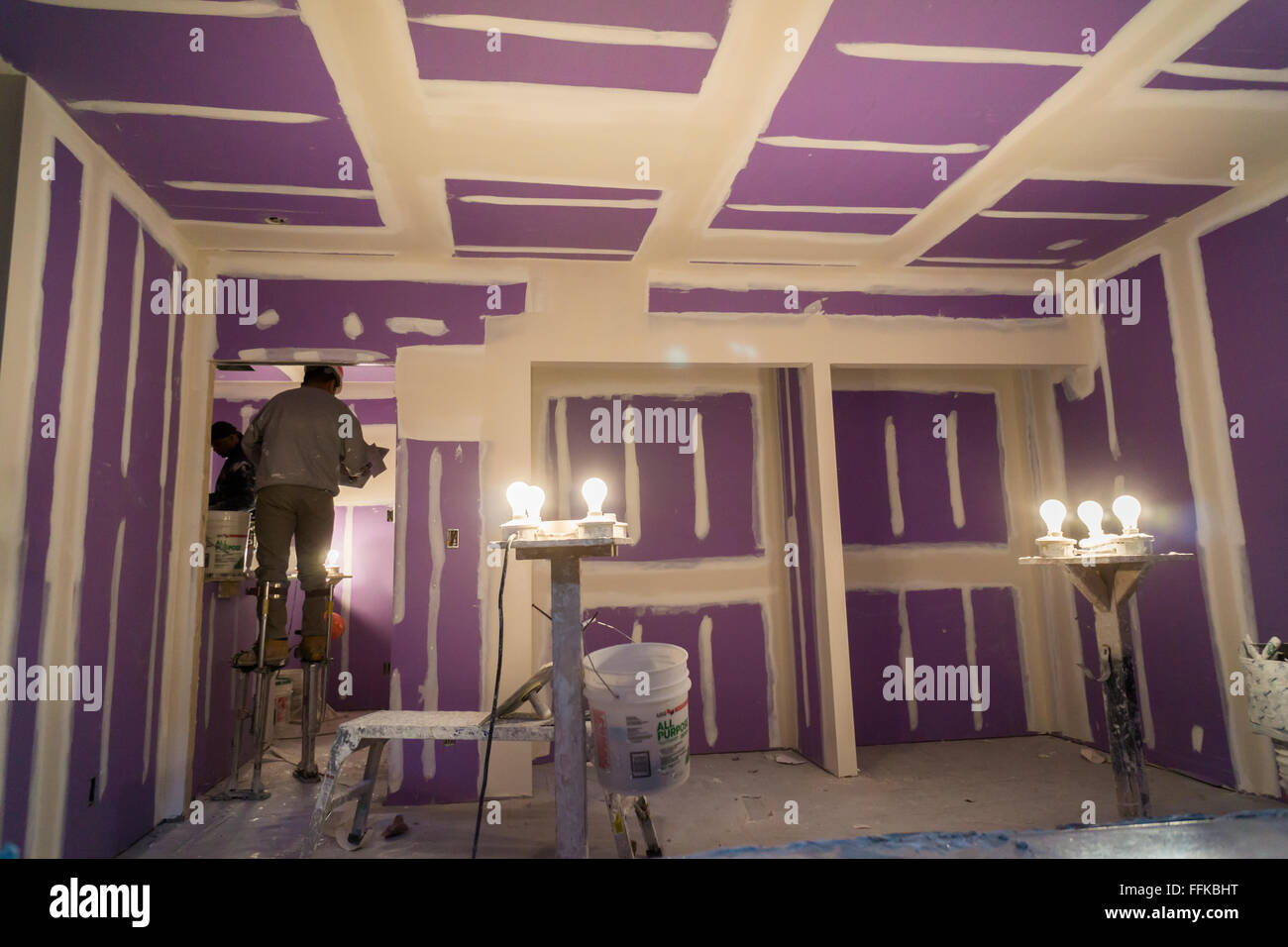 Plâtriers travaillent à l'intérieur des logements modulaires dans une usine dans le Brooklyn Navy Yard, à New York, le jeudi 11 février, 2016. En raison de la hausse des loyers et de la nécessité d'un espace spécialisé l'usine va fermer après après ce travail, le logement pour le développement de Spring Creek Néhémie. Steiner Studios, un autre locataire à la Brooklyn Navy Yard sera prise en charge de l'espace. (© Richard B. Levine) Banque D'Images