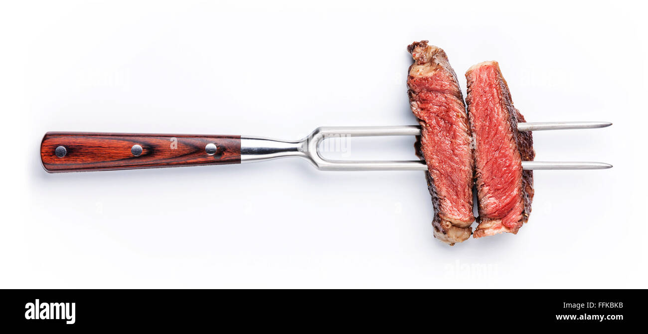 Tranches de steak de boeuf sur fourchette à viande sur fond blanc Banque D'Images