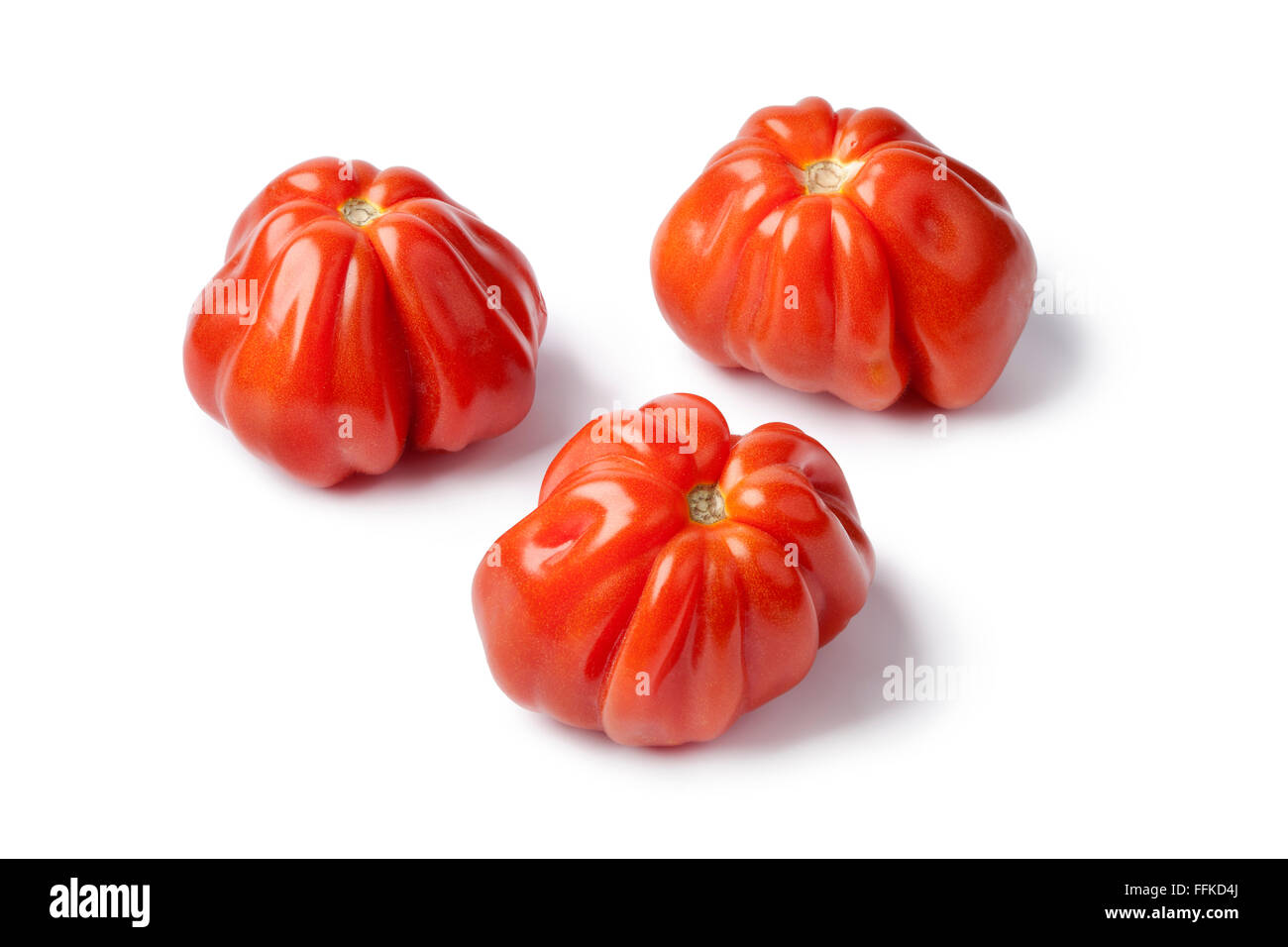 Coeur de rouges frais boeuff tomates sur fond blanc Banque D'Images