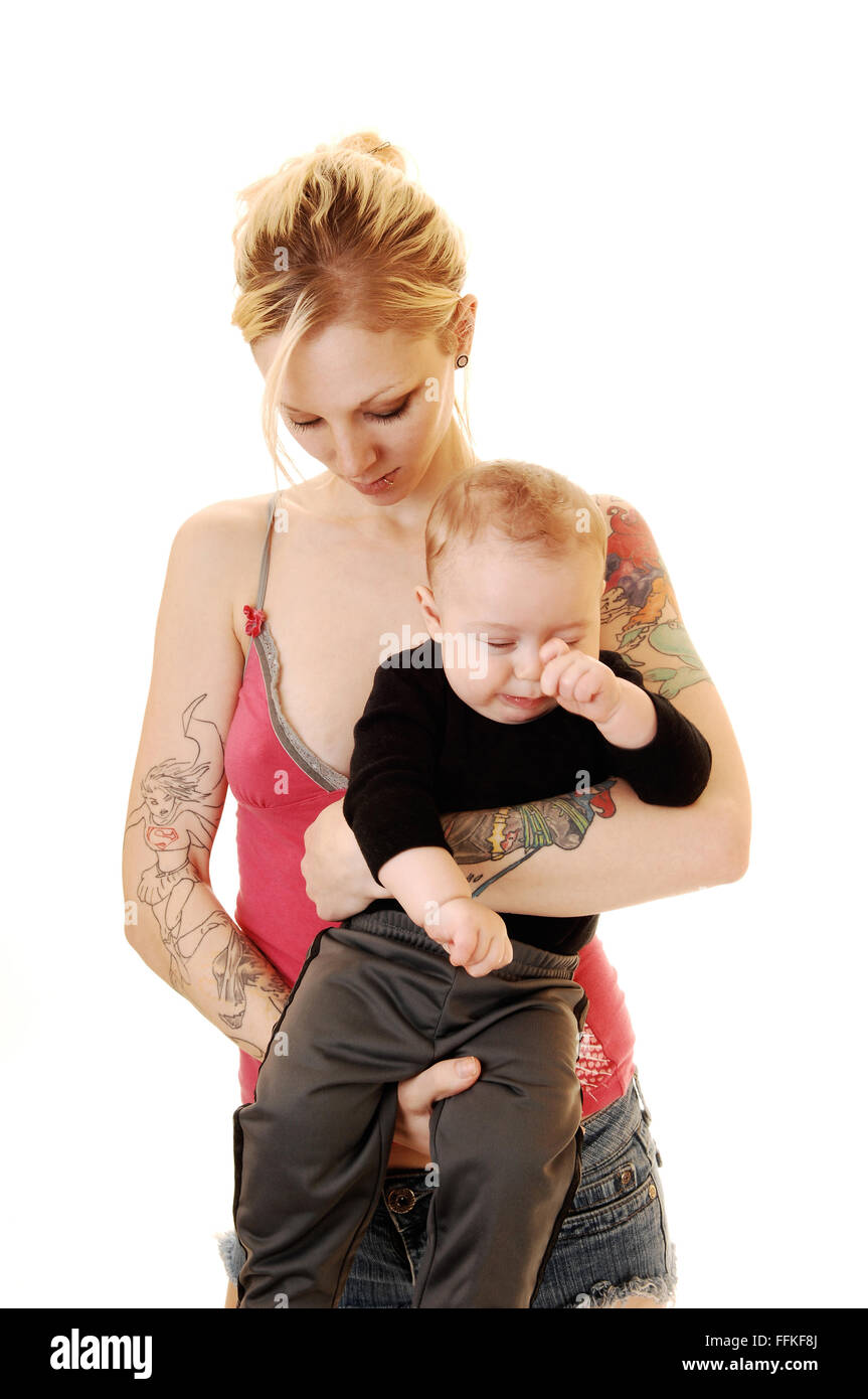 Un Petit Garcon Tres Fatigue Bebe Dans Les Bras De Sa Mere Une Jeune Femme Blonde En Short Et Avec Tatouage Sur Son Corps Debout Pour Photo Stock Alamy