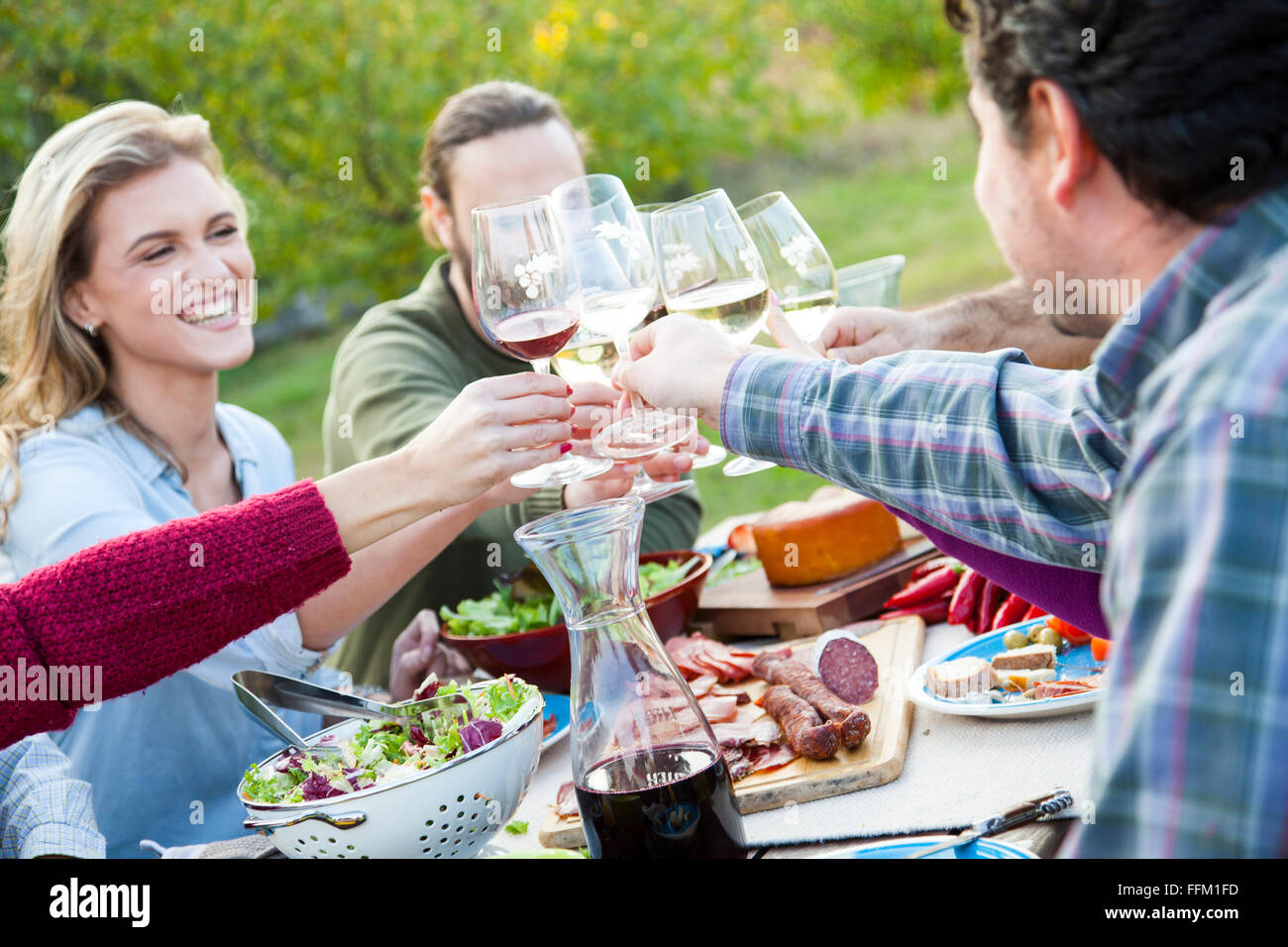 Groupe d'amis boire du vin sur garden party Banque D'Images