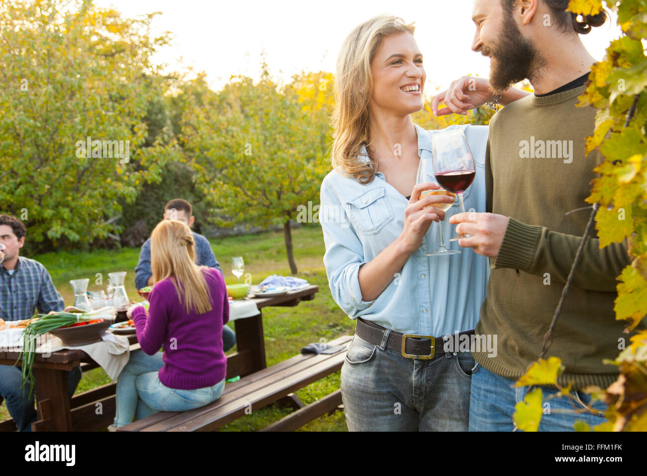 Groupe d'amis boire du vin sur garden party Banque D'Images