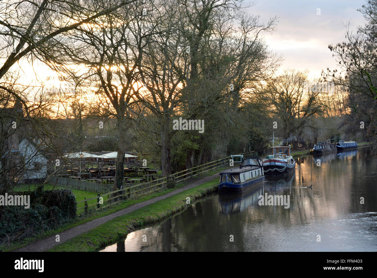 Canal qui coule avec un beau coucher de soleil derrière l'homme rusé, Burghfield, Reading, Berkshire, Royaume-Uni. Charles Dye / Alamy Live News Banque D'Images
