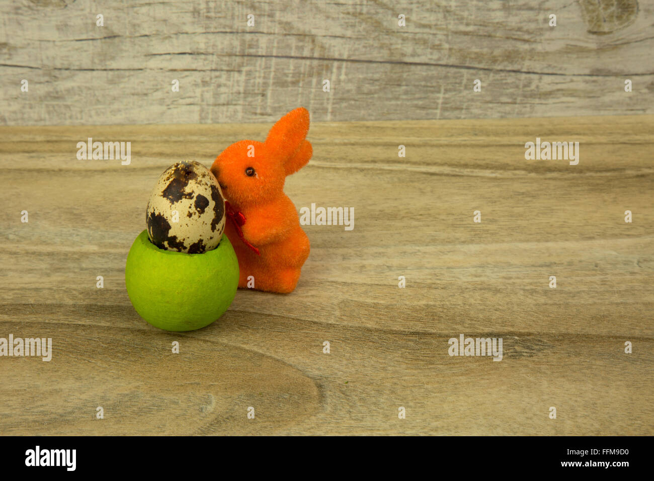 Figurine lapin de Pâques Orange fondée sur une base écologique avec un peu d'oeuf de caille sur une vieille table en bois. Vue horizontale. Banque D'Images