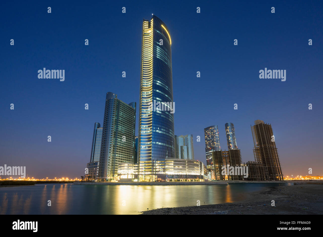 Vue de nuit sur les gratte-ciel modernes en construction au nouveau quartier d'affaires appelée Ville des Lumières sur Al Reem Island à Abu Dha Banque D'Images