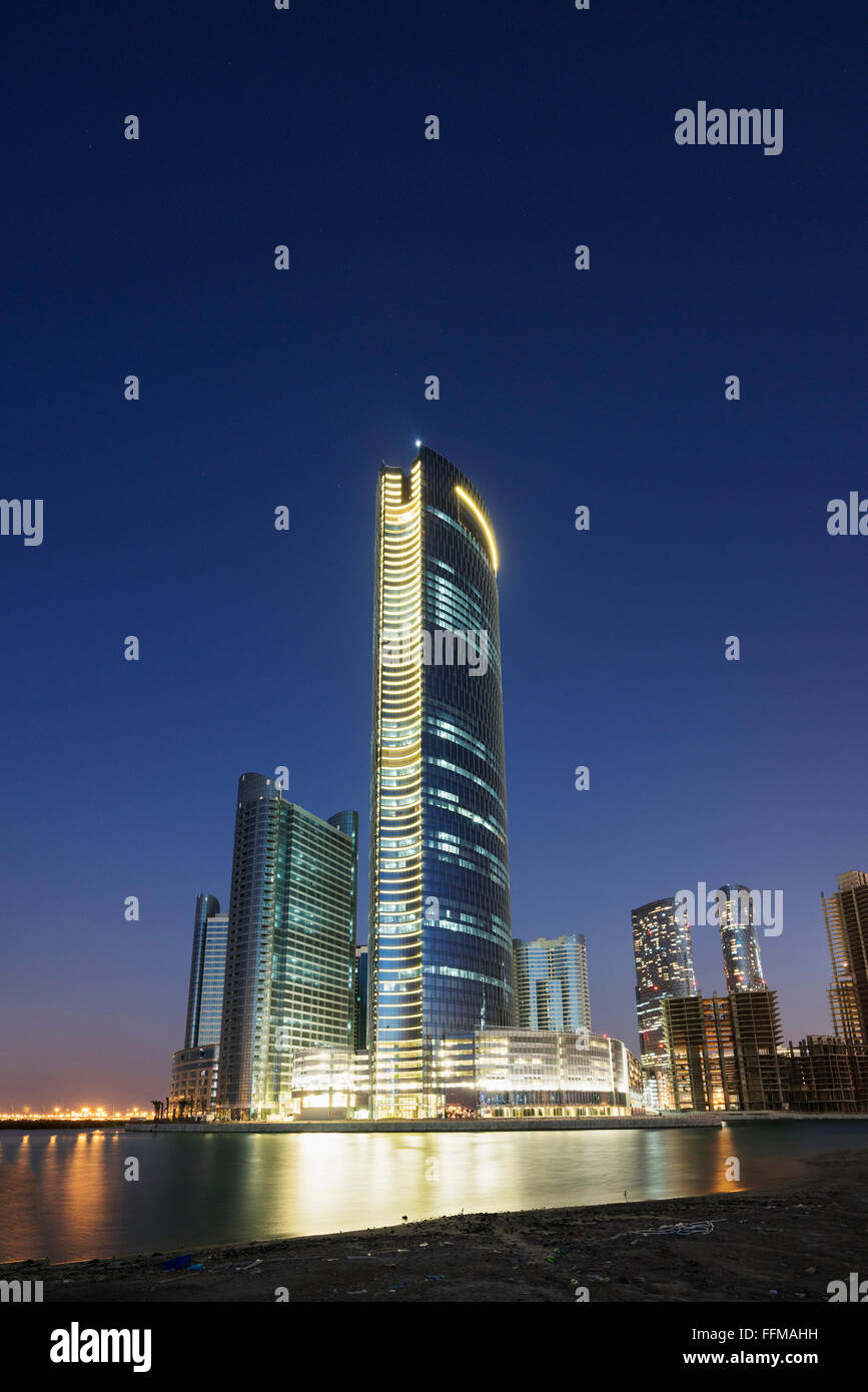 Vue de nuit sur les gratte-ciel modernes en construction au nouveau quartier d'affaires appelée Ville des Lumières sur Al Reem Island à Abu Dha Banque D'Images