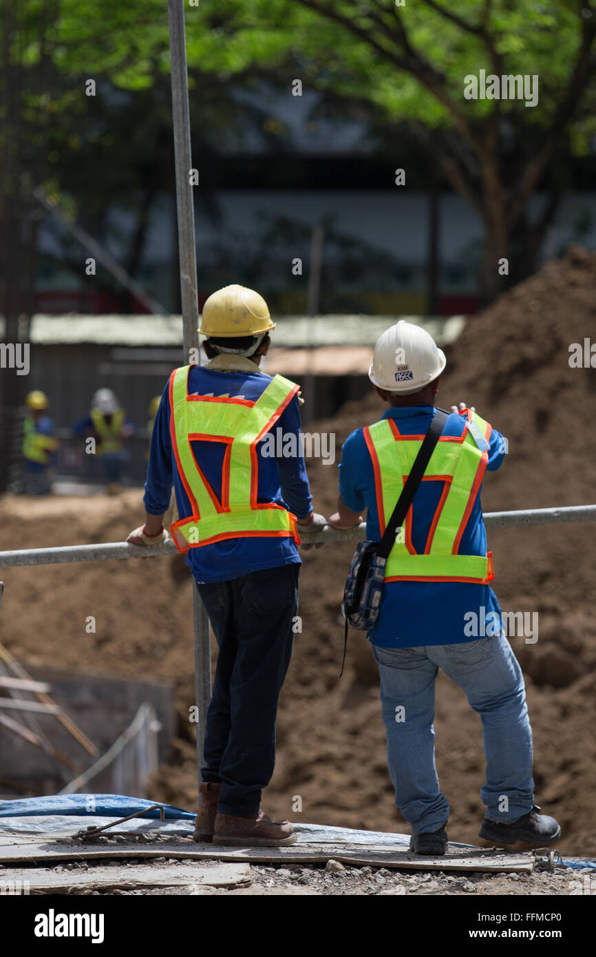 Deux travailleurs de la construction donnant sur un chantier dans la ville de Cebu, Philippines Banque D'Images