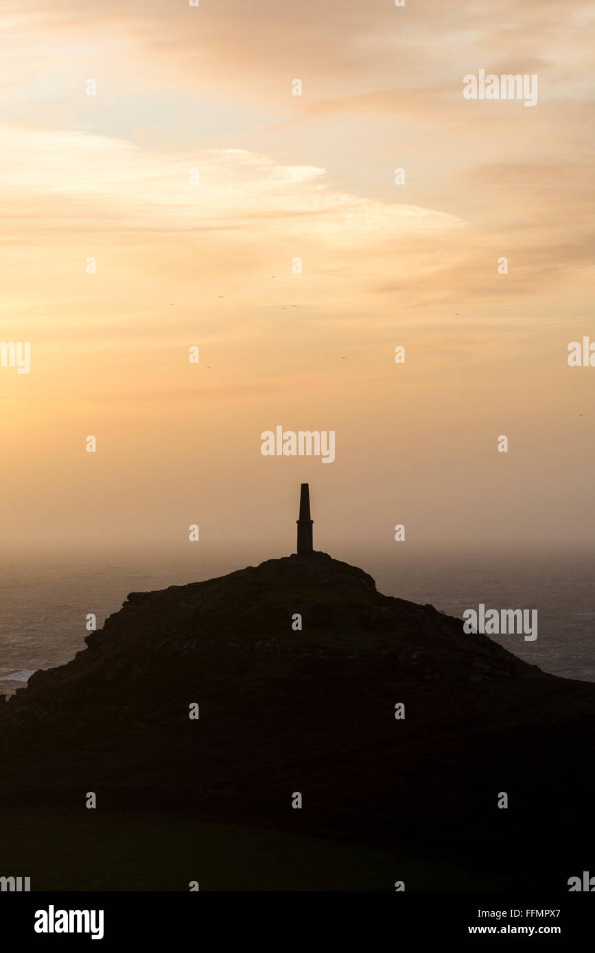 La tour de guet à Cape Cornwall sur la côte de Cornouailles, en silhouette au coucher du soleil. Banque D'Images