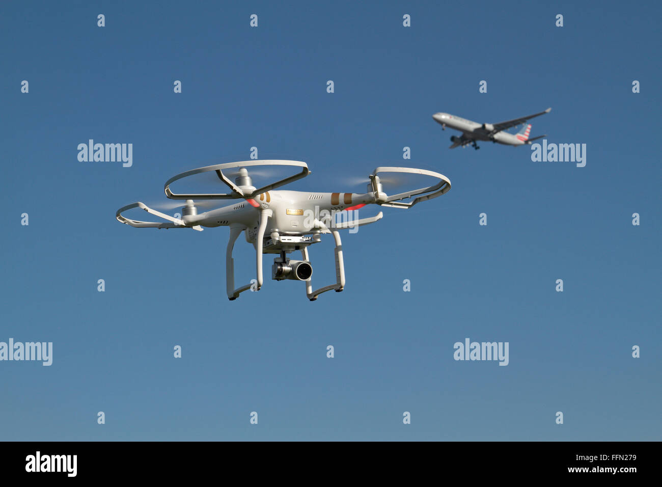 Un fantôme 3 DJI quadcopter professionnel (ou drone) avec les gardes de sécurité et un joint prop avion américain passant derrière. Banque D'Images