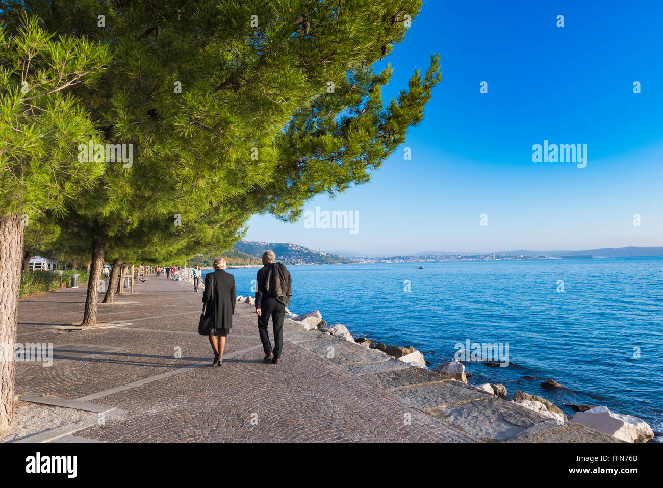 Couple en train de marcher le long de la promenade le long de la côte de la mer Adriatique à Trieste, Italie, Europe Banque D'Images