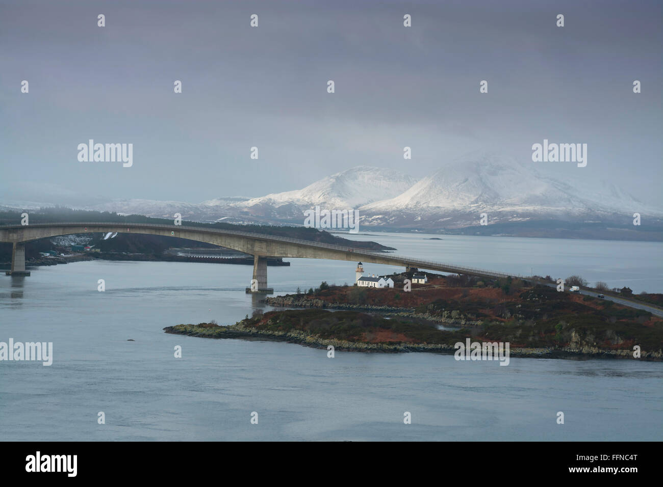 Skye bridge à Kyle of Lochalsh avec neige et montagnes et le phare Banque D'Images