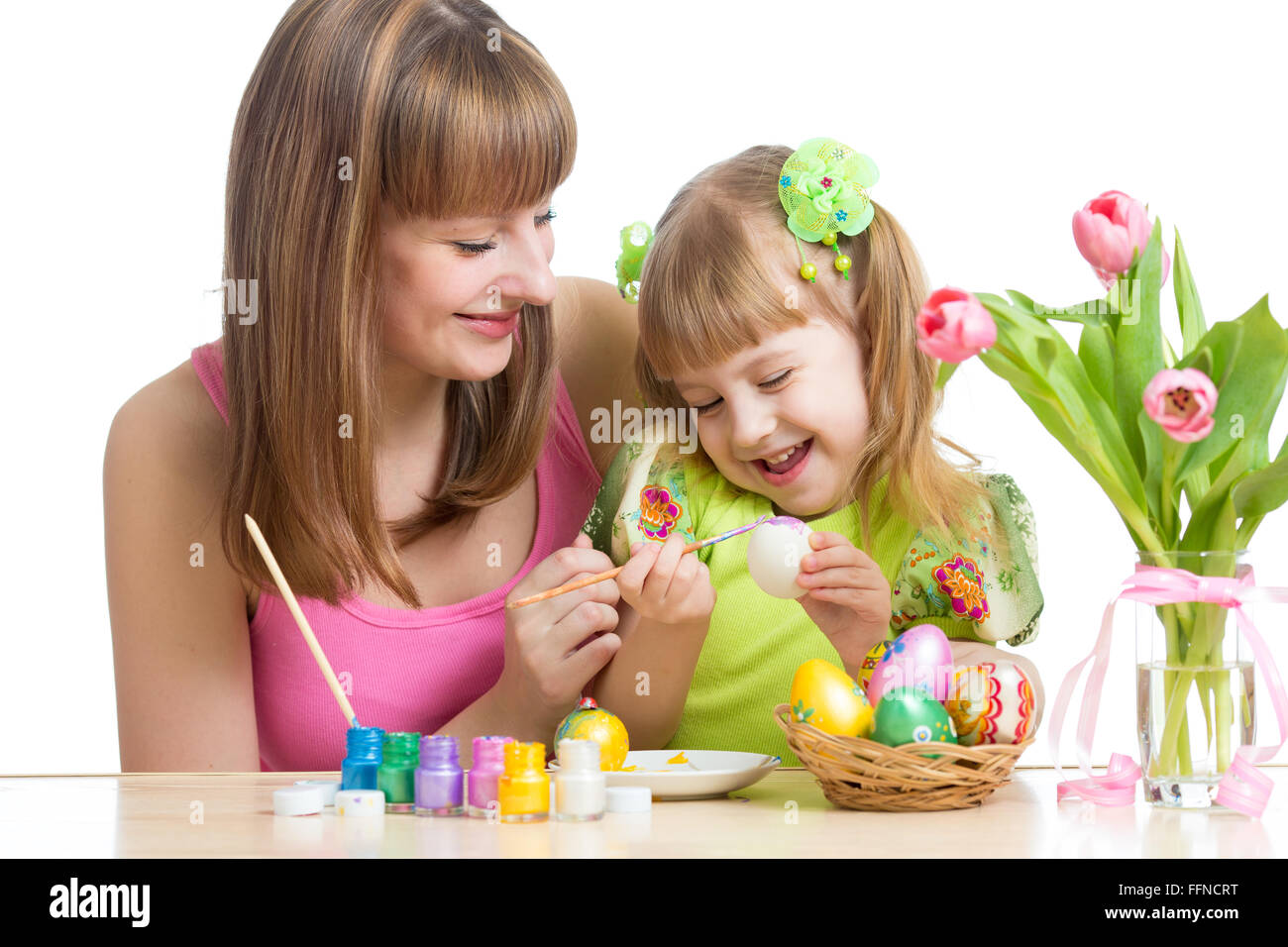 Mère et enfant fille heureuse à la préparation de pâques et oeufs à colorier avec brosse Banque D'Images