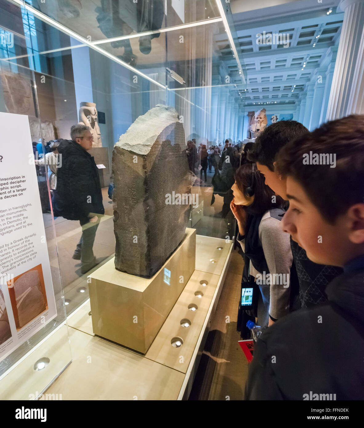 Les visiteurs rassemblés autour de la pierre de Rosette dans l'Egypte ancienne galerie sculpture égyptienne, British Museum, Londres, Angleterre, Royaume-Uni Banque D'Images