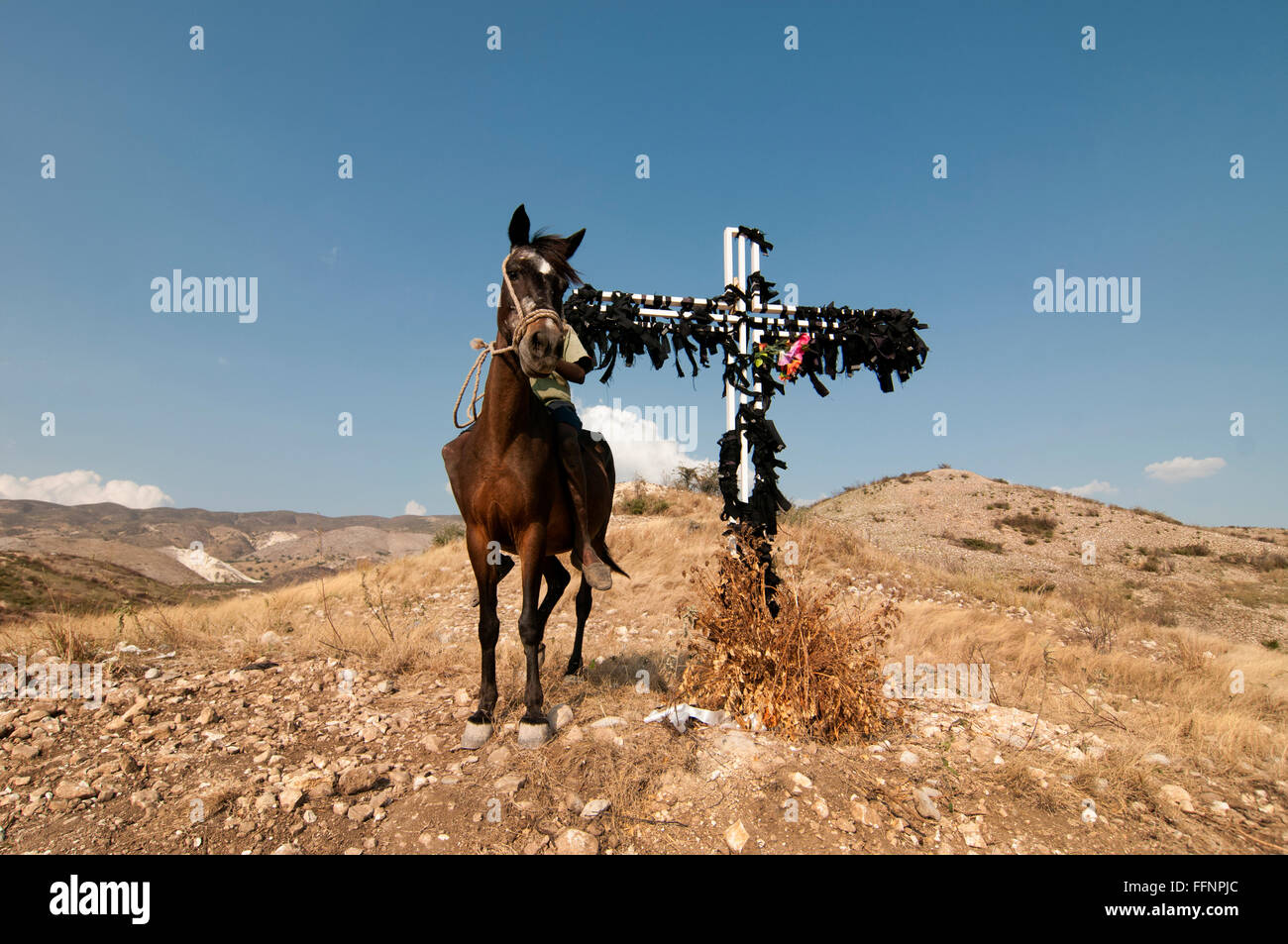 Un homme monte à cheval sur un charnier de 20 pieds de profondeur, l'un des lieux de sépulture improvisés pour les victimes du tremblement de terre de magnitude 7,0 qui a frappé Haïti le 12 janvier 2010 Banque D'Images