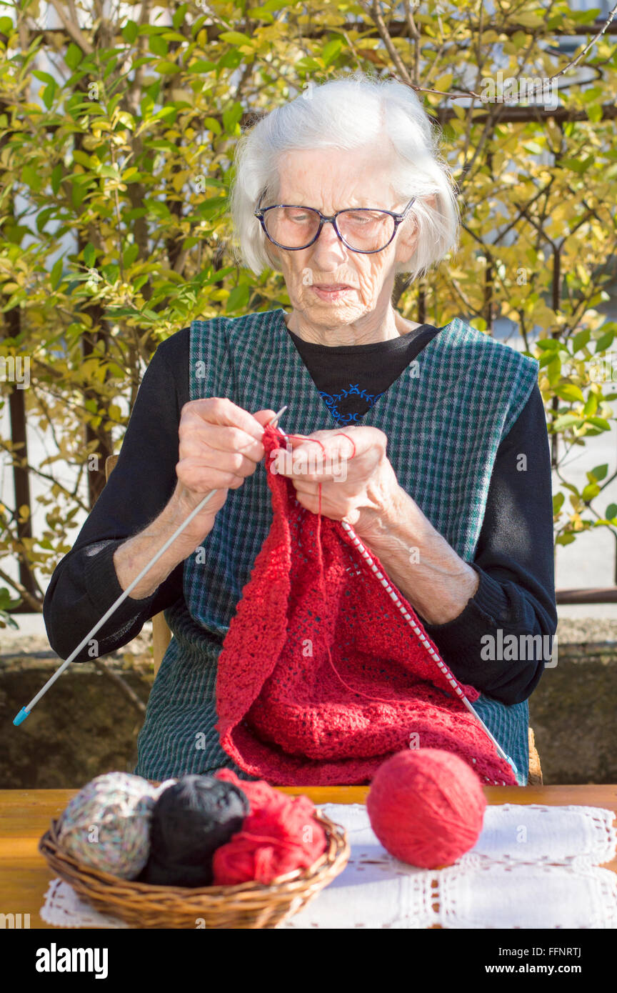 Femme de 90 ans un tricot pull rouge à l'extérieur Banque D'Images