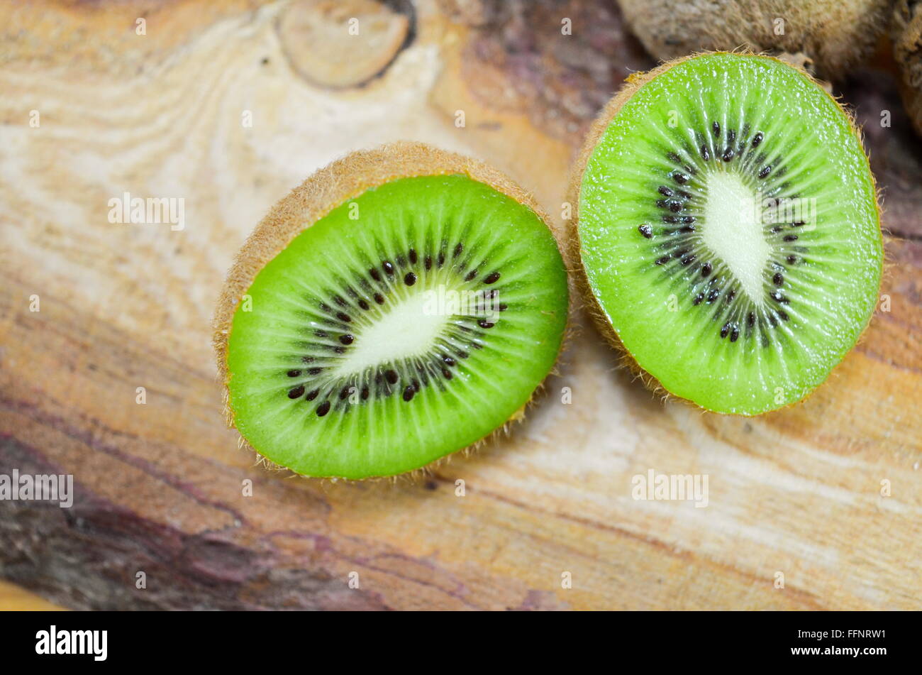 Moitié juteux kiwi sur une planche en bois rustique Banque D'Images