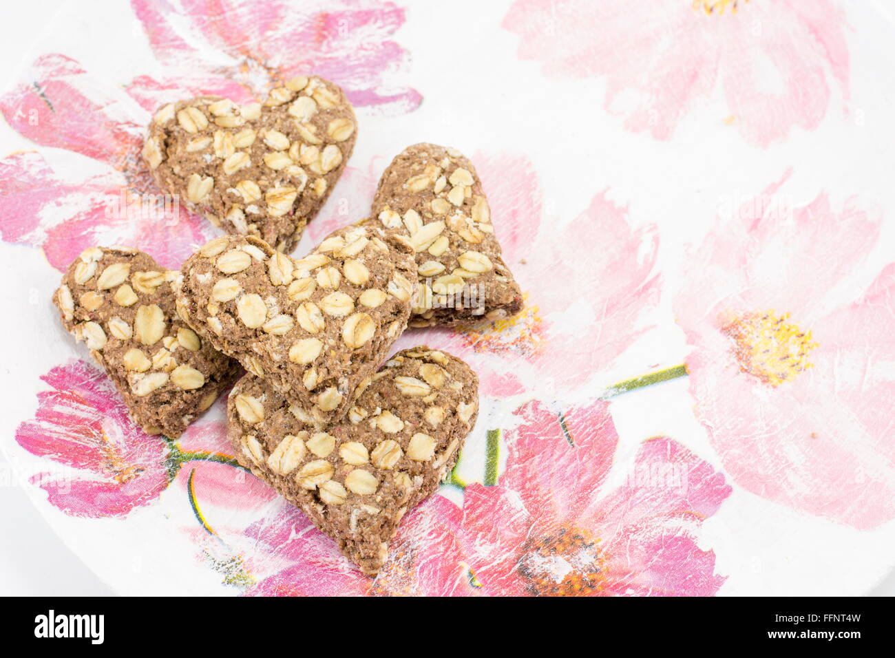 Heartshaped cookies faits de farine intégrale sur un plateau decoupaged Banque D'Images