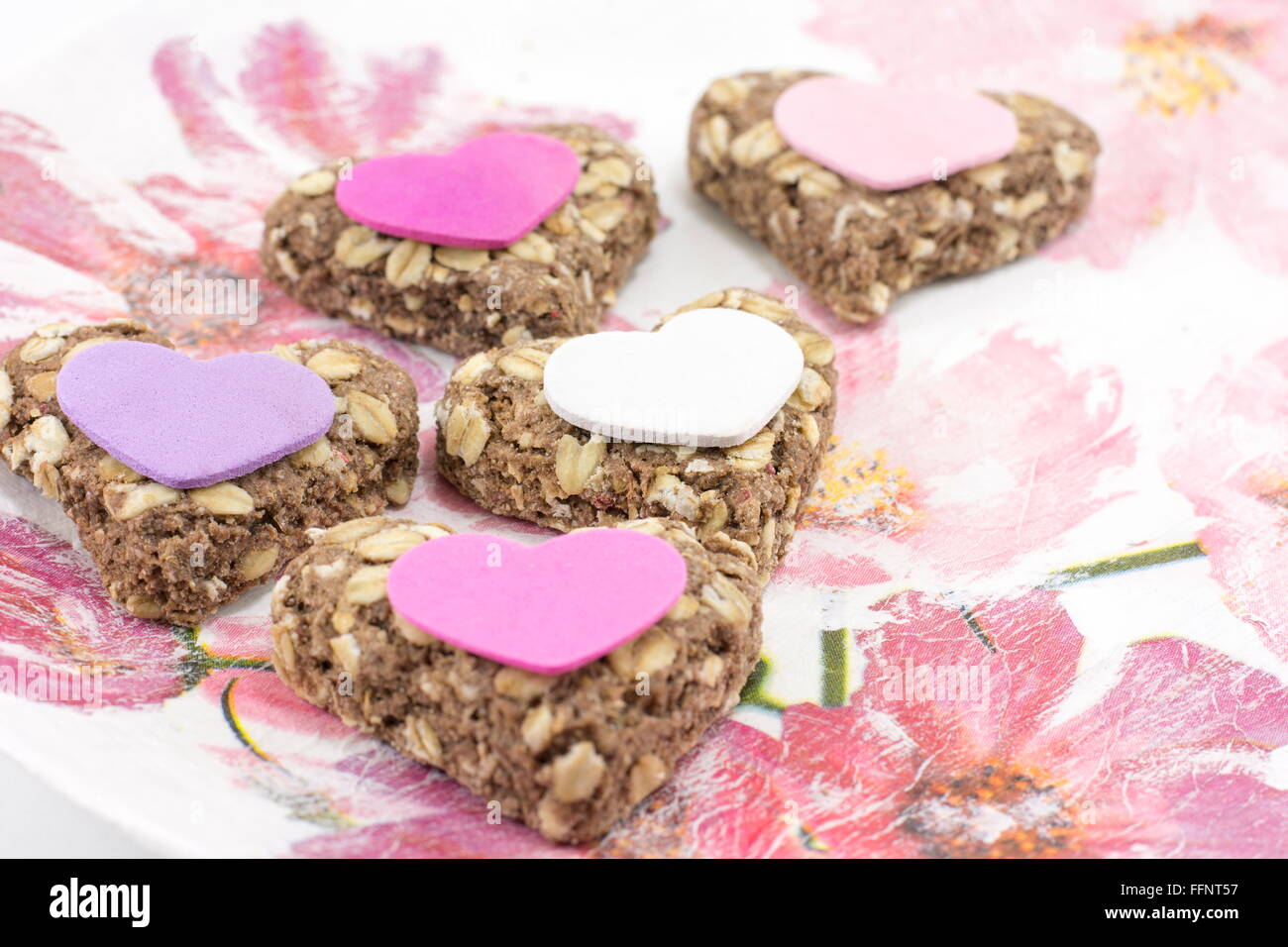 Heartshaped cookies faits de farine intégrale sur un plateau decoupaged Banque D'Images