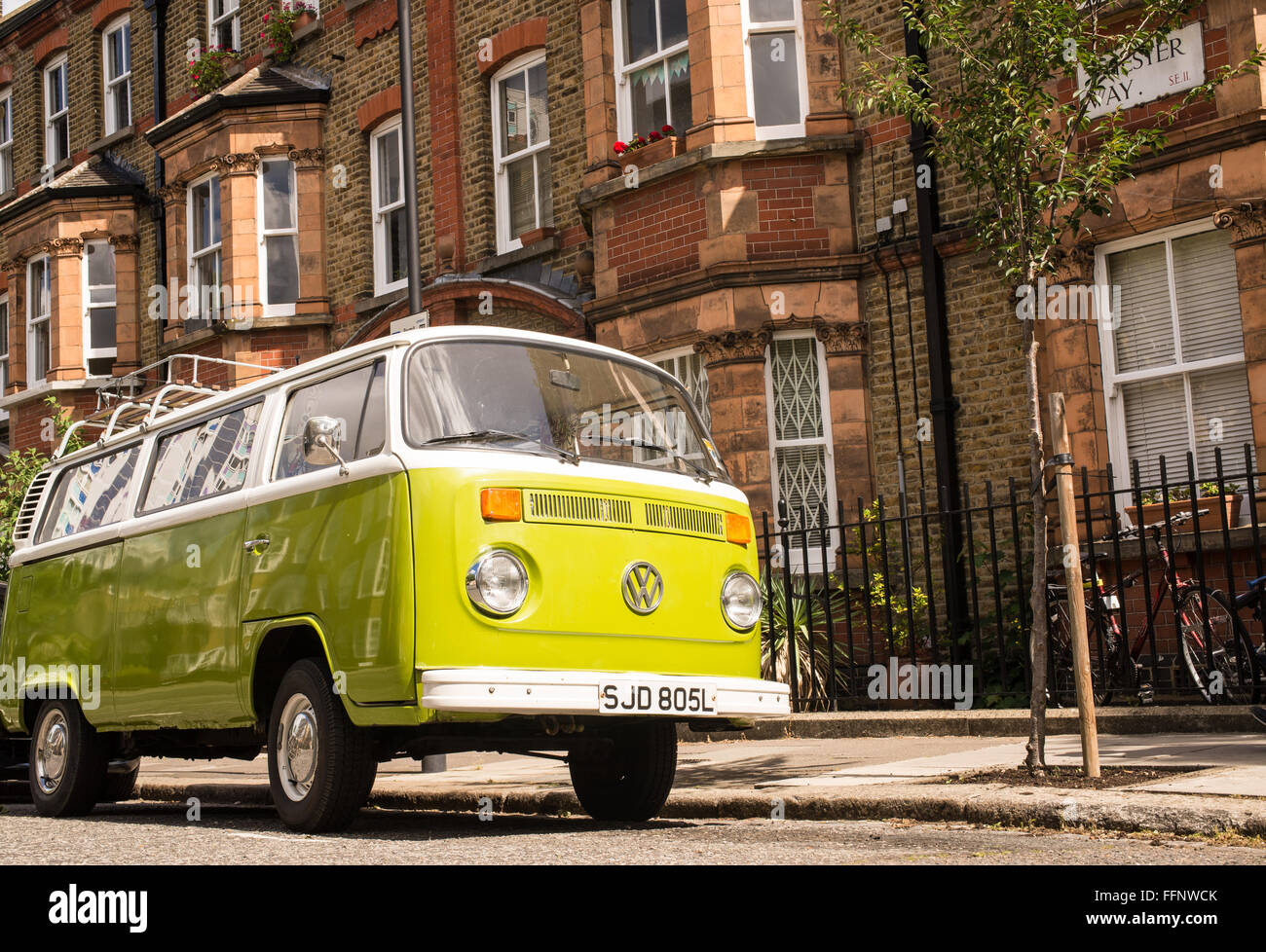 Old vintage green van stationné dans une rue avec des maisons victoriennes en arrière-plan Banque D'Images