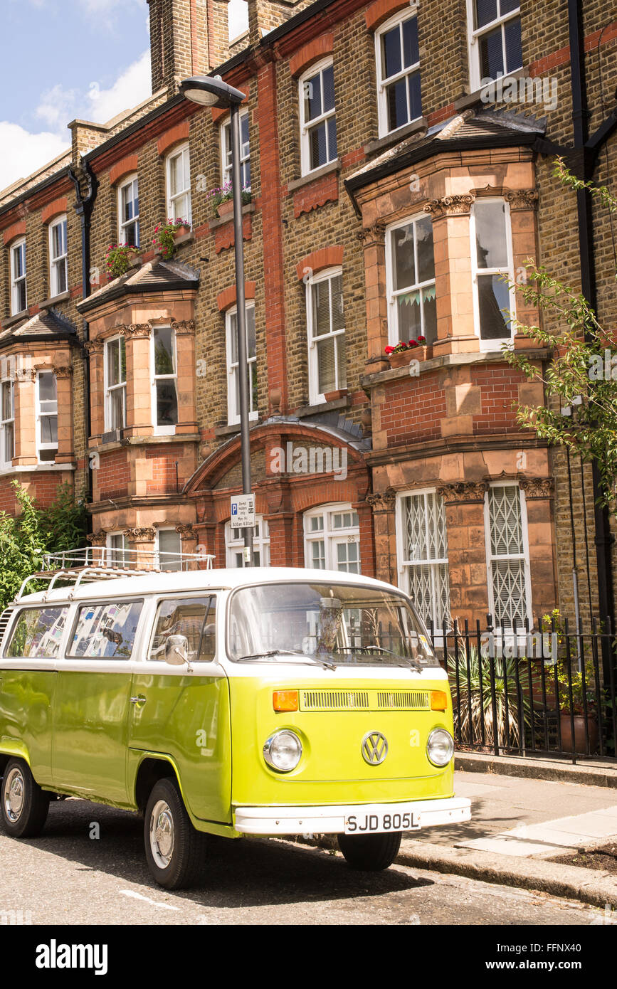 Old vintage green van stationné dans une rue avec des maisons victoriennes en arrière-plan Banque D'Images