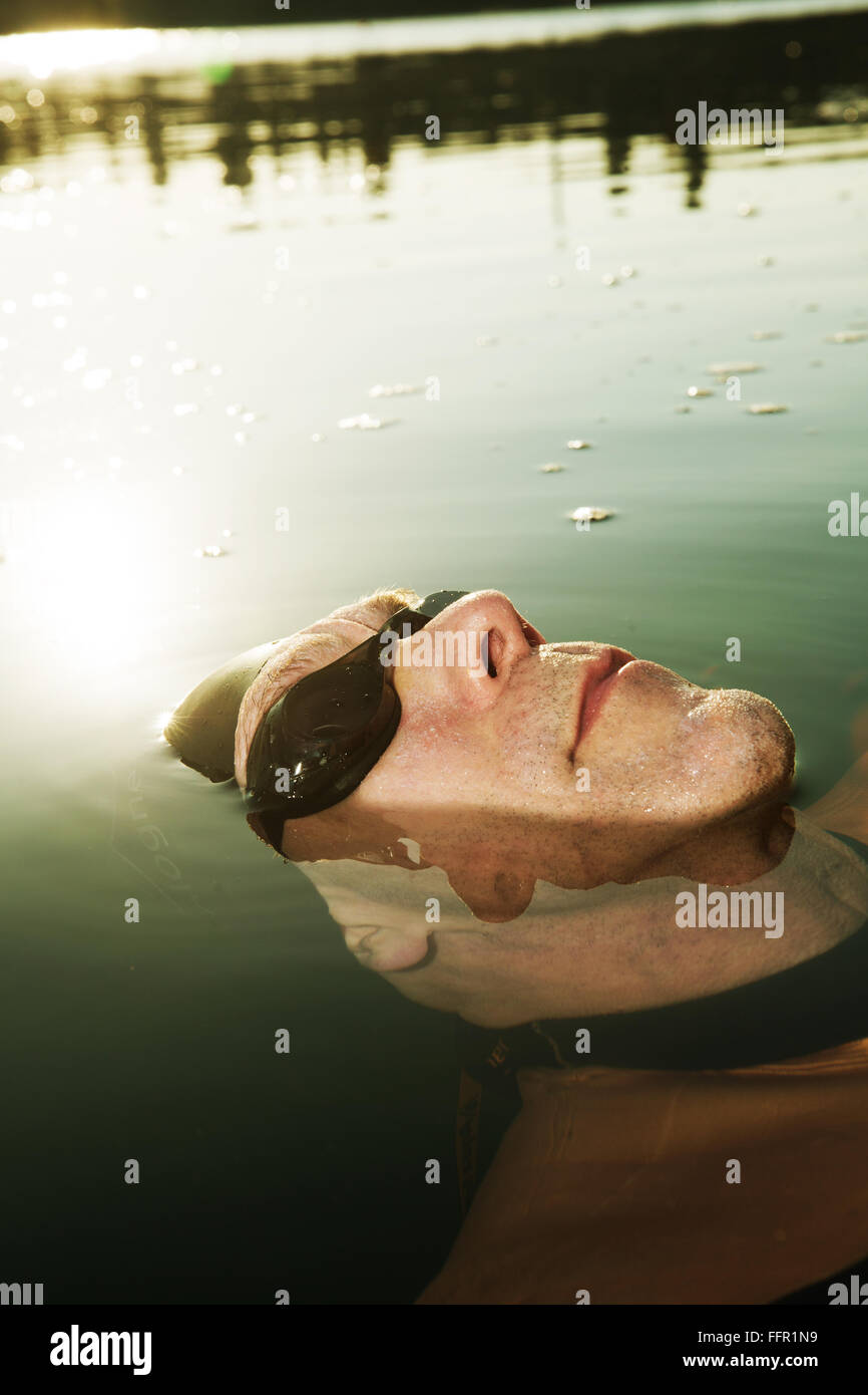 Homme avec lunettes de natation, chef de la moitié submergé dans le lac, Allemagne Banque D'Images