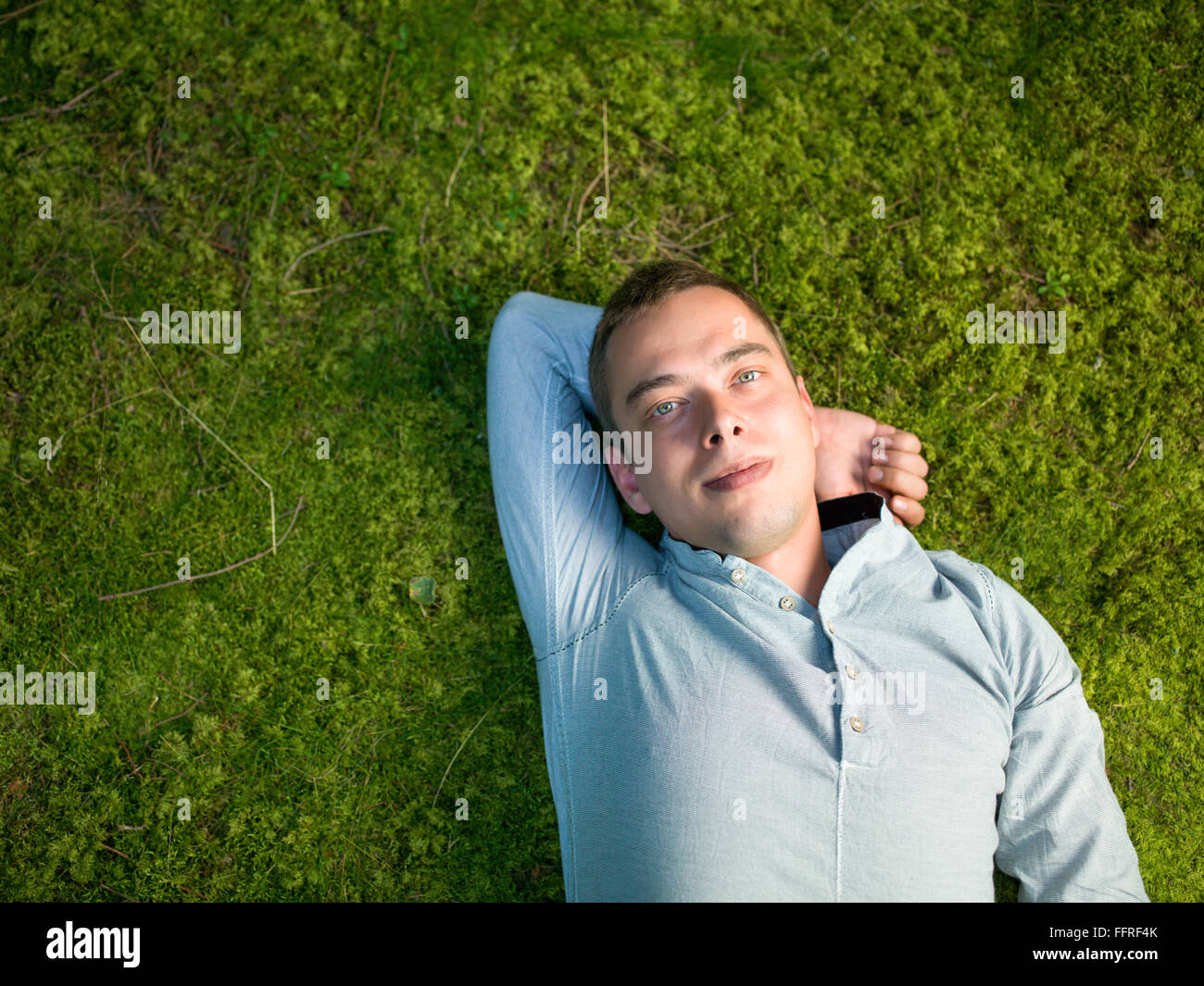 Young man lying on green moss , détendez-vous profiter de la nature Banque D'Images