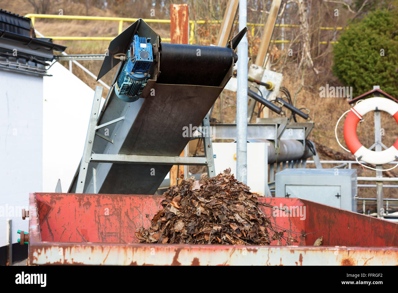 Système automatisé de l'enlèvement des débris à une centrale hydroélectrique. Une courroie de transport des feuilles et d'autres trucs sur un récipient. Partie de tas Banque D'Images