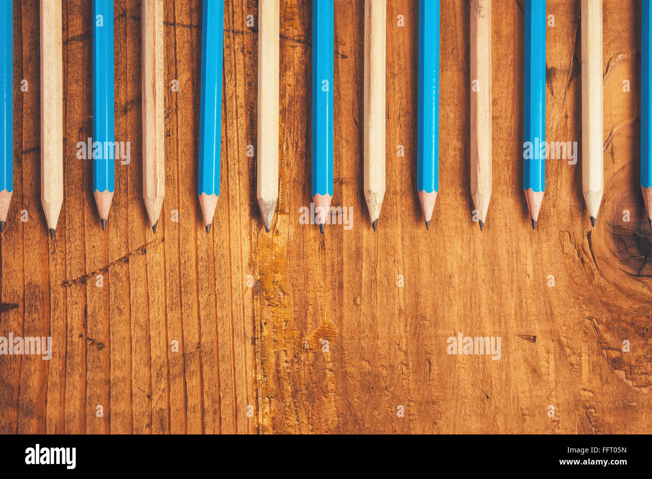 Bleu et marron crayons alignés sur une table en bois rustique, vue supérieure avec copie espace vierge Banque D'Images