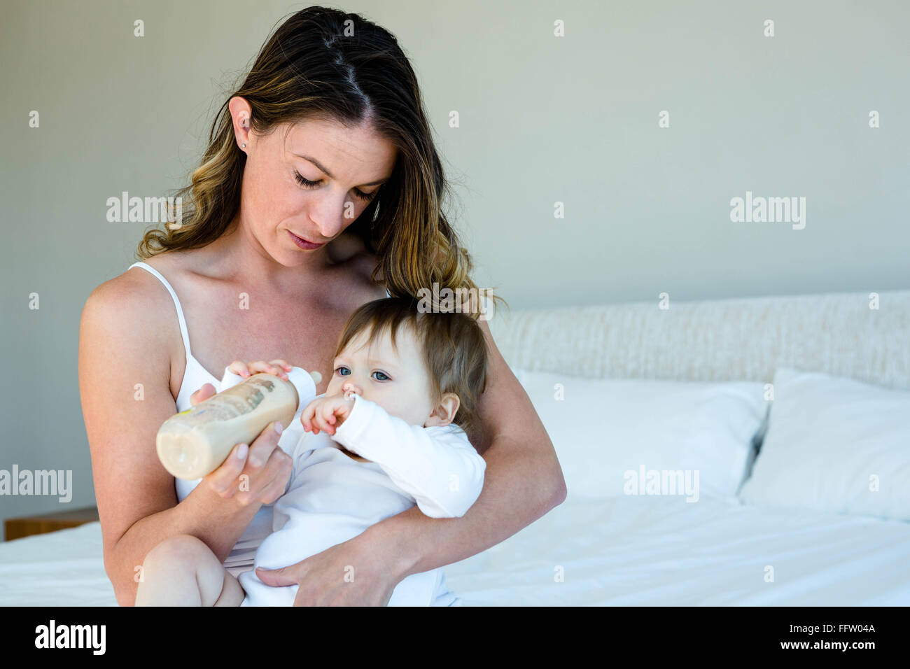 Thoughtful woman biberon un bébé Banque D'Images