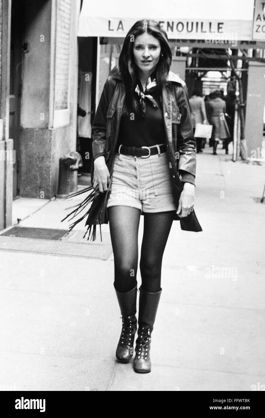La mode féminine des années 1970. /NA femme portant short, une veste en cuir  à franges, et des bottes à l'extérieur de la Grenouille restaurant sur la  52e rue à Manhattan, New